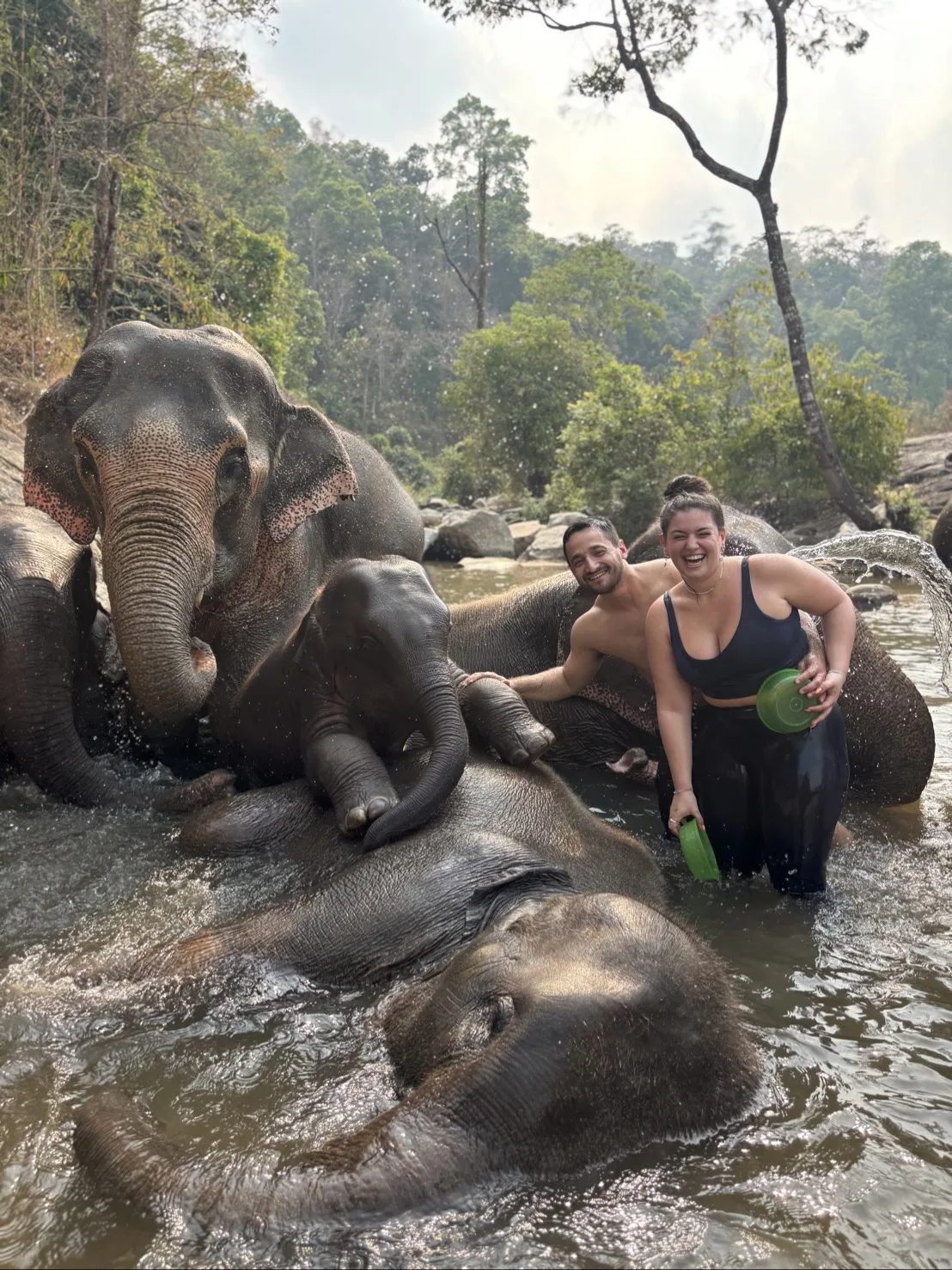 Travellers with elephants in a river